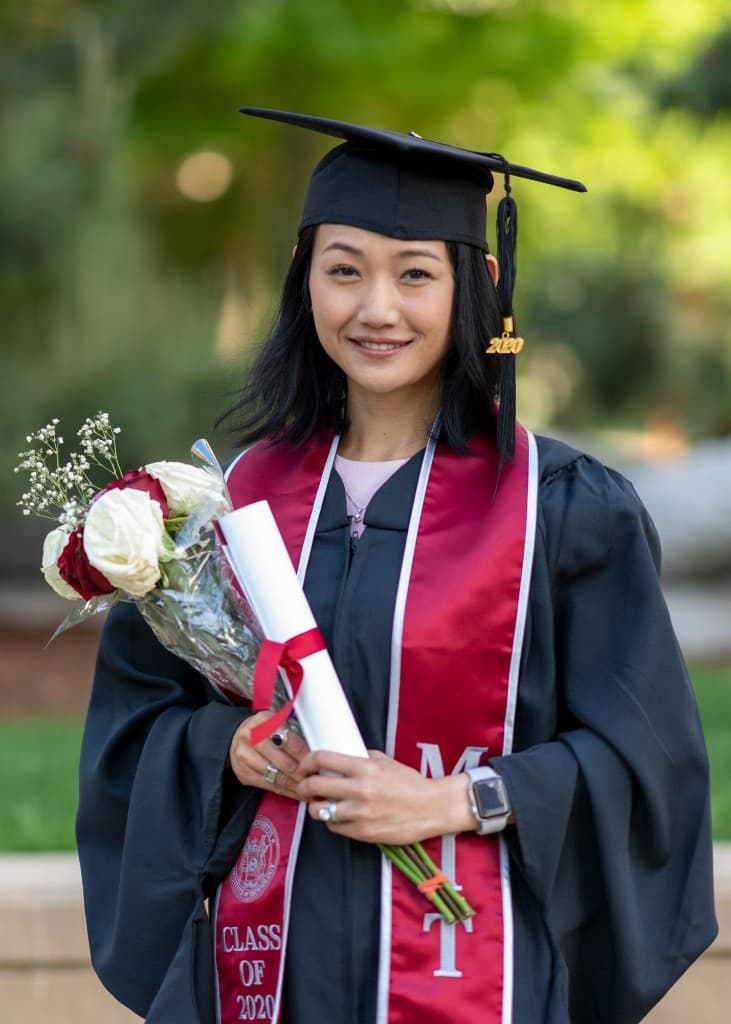 Graduate holding flowers and a diploma