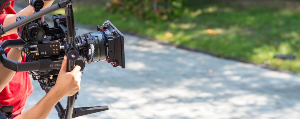 Movie shooting or video production and film crew team with camera equipment.