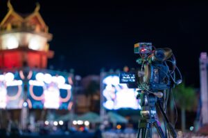 Professional video crew filming event on stage. Movie production expertise utilizing multimedia for