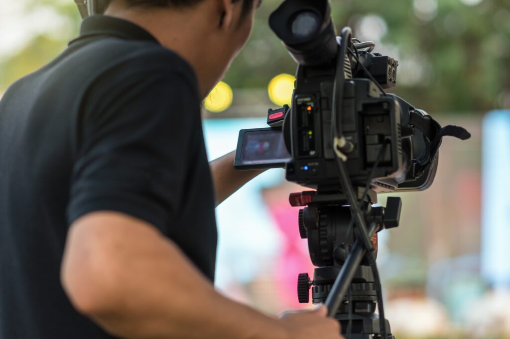 Rear side of Video Cameraman taking photograp to the stage, event and seminar production